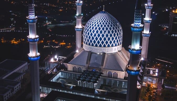 white and blue dome concrete building with 4-towers during night time