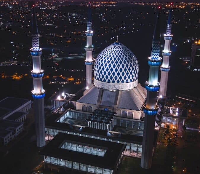 white and blue dome concrete building with 4-towers during night time