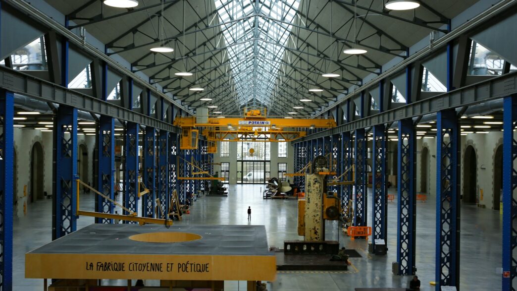An industrial hall with machinery and high ceilings.